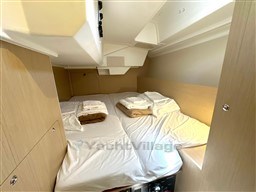 Cozy cabin interior of 2021 Beneteau Oceanis 38.1 yacht with neatly arranged bedding.