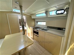 Modern kitchen interior of 2021 Beneteau Oceanis 38.1 yacht with light wood finish.