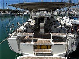2021 Beneteau Oceanis 38.1 sailboat with dual steering wheels in a marina.