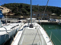 2021 Beneteau Oceanis 38.1 sailboat docked in a marina, surrounded by other boats.