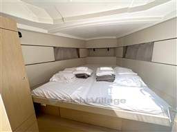 Cozy cabin interior of 2021 Beneteau Oceanis 38.1 yacht with neatly arranged bedding.