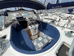 Cockpit of 2001 Beneteau Oceanis 40 CC sailboat with blue seating and wooden steering wheel.