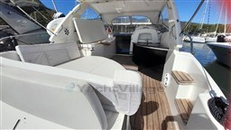 2013 Rio Yachts Rio 36 interior with white seating and wooden deck in a marina.
