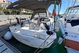 2024 Dufour 37 sailboat docked, featuring dual steering wheels and a shaded cockpit.