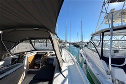 2024 Dufour 37 yacht docked in a sunny marina, showcasing sleek design and spacious deck.