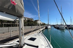 2024 Dufour 37 sailboat docked in a sunny marina with clear blue skies.