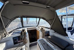2024 Dufour 37 yacht cockpit with canopy and ropes, docked in marina.
