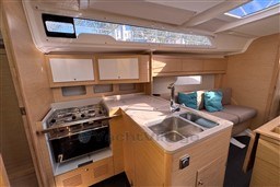 Modern 2024 Dufour 37 yacht interior with kitchen and seating area.
