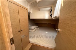 2024 Dufour 37 yacht cabin interior with cozy bed and wooden cabinetry.