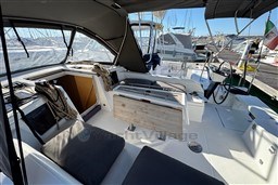 2024 Dufour 37 yacht cockpit with seating, steering wheel, and marina view.