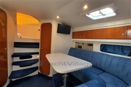 Interior of 2002 Cranchi Smeraldo 37 yacht with blue seating and wooden cabinets.