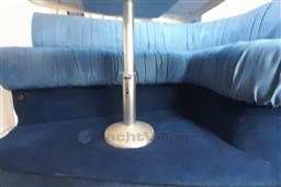 Blue interior seating of 2002 Cranchi Smeraldo 37 yacht with metal table support.