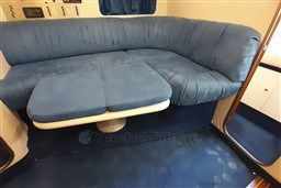 Blue upholstered seating area inside a 2002 Cranchi Smeraldo 37 yacht cabin.