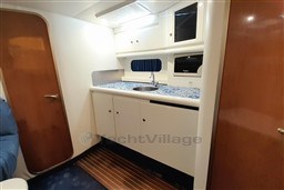 Interior of 2002 Cranchi Smeraldo 37 yacht with kitchenette and wooden accents.