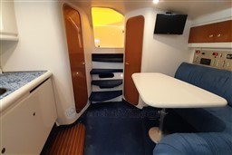 Interior of 2002 Cranchi Smeraldo 37 yacht with seating, table, and control panel.