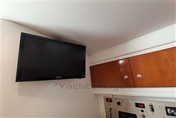 Interior of 2002 Cranchi Smeraldo 37 with wall-mounted TV and wooden cabinets.