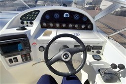 Cockpit view of 2002 Cranchi Smeraldo 37 yacht, featuring steering wheel and control panel.