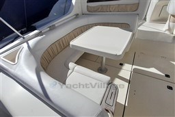 2002 Cranchi Smeraldo 37 yacht interior with cushioned seating and table.