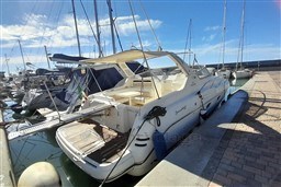 2002 Cranchi Smeraldo 37 yacht docked at marina under clear blue sky.