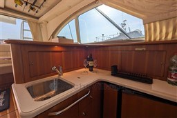 Luxurious 2005 Tiara Yachts 3900 Convertible interior with kitchenette and wine setup.