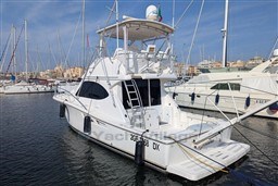 2005 Tiara Yachts 3900 Convertible docked in a marina, surrounded by sailboats.