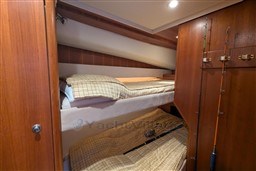 2005 Tiara Yachts 3900 Convertible cabin with bunk beds and fishing rods.