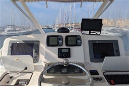 Helm of 2005 Tiara Yachts 3900 Convertible with navigation equipment and marina view.