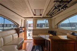 Luxurious interior of 2005 Tiara Yachts 3900 Convertible with leather seating and fishing rods.