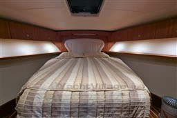 Luxurious bedroom interior of 2005 Tiara Yachts 3900 Convertible with cozy bedding.