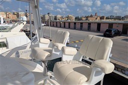 2005 Tiara Yachts 3900 Convertible with white captain chairs docked at a marina.