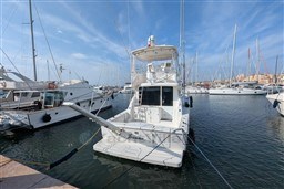 2005 Tiara Yachts 3900 Convertible docked in a marina under a clear blue sky.