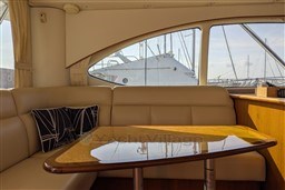 Interior of 2005 Tiara Yachts 3900 Convertible with elegant seating and wooden table.