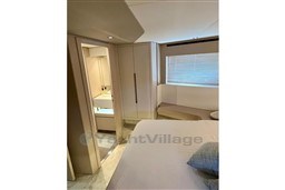 Luxurious interior of 2022 Azimut 68 Fly yacht with modern bedroom and ensuite bathroom.