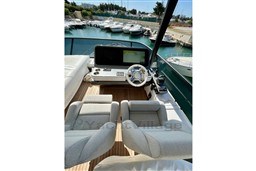 Flybridge helm of 2022 Azimut 68 Fly yacht with modern controls and seating.