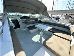 1993 Pershing 38 yacht interior with seating area and table, docked at marina.