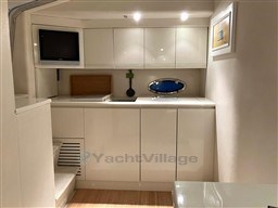 Interior of 1993 Pershing 38 yacht with modern white cabinetry and small TV.