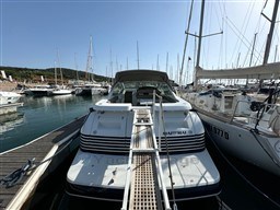 1993 Pershing 38 yacht docked at a marina, surrounded by sailboats.