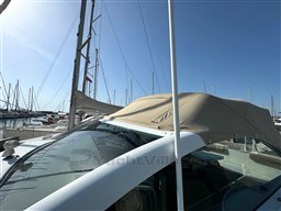 1993 Pershing 38 yacht with beige canopy docked at marina under clear blue sky.