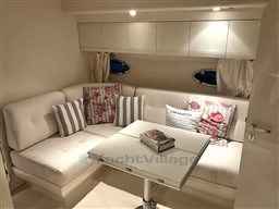 Luxurious interior of a 1993 Pershing 38 yacht with elegant seating and decorative pillows.