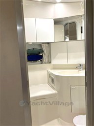 Bathroom interior of a 1993 Pershing 38 yacht, featuring sleek white cabinetry.