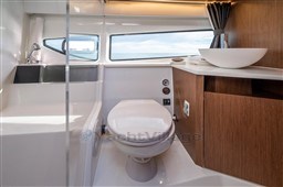 Modern bathroom in 2023 Beneteau Antares 11 yacht with sleek design and wooden cabinetry.
