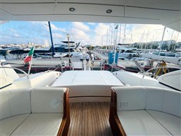 Luxurious 2005 Mangusta 72 Open yacht docked at a marina with elegant seating.