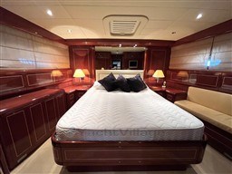 Luxurious bedroom interior of 2005 Mangusta 72 Open yacht with elegant wood paneling.