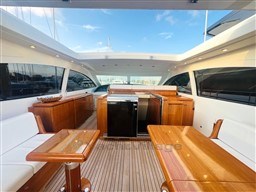 Luxurious 2005 Mangusta 72 Open yacht interior with elegant wood furnishings and spacious seating.