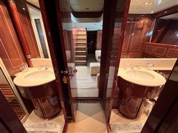 Luxurious 2005 Mangusta 72 Open yacht interior with dual sinks and elegant wood finishes.