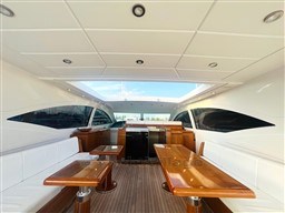 Luxurious interior of 2005 Mangusta 72 Open yacht with elegant wood and white seating.