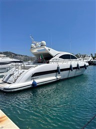 2005 Mangusta 72 Open yacht docked in a marina under clear blue skies.
