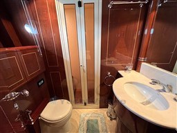 Luxurious bathroom in 2005 Mangusta 72 Open yacht with elegant wood paneling and modern fixtures.