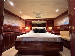 Luxurious bedroom interior of 2005 Mangusta 72 Open yacht with elegant wood finishes.