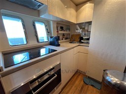 Luxurious kitchen interior of a 2005 Mangusta 72 Open yacht with modern appliances.
